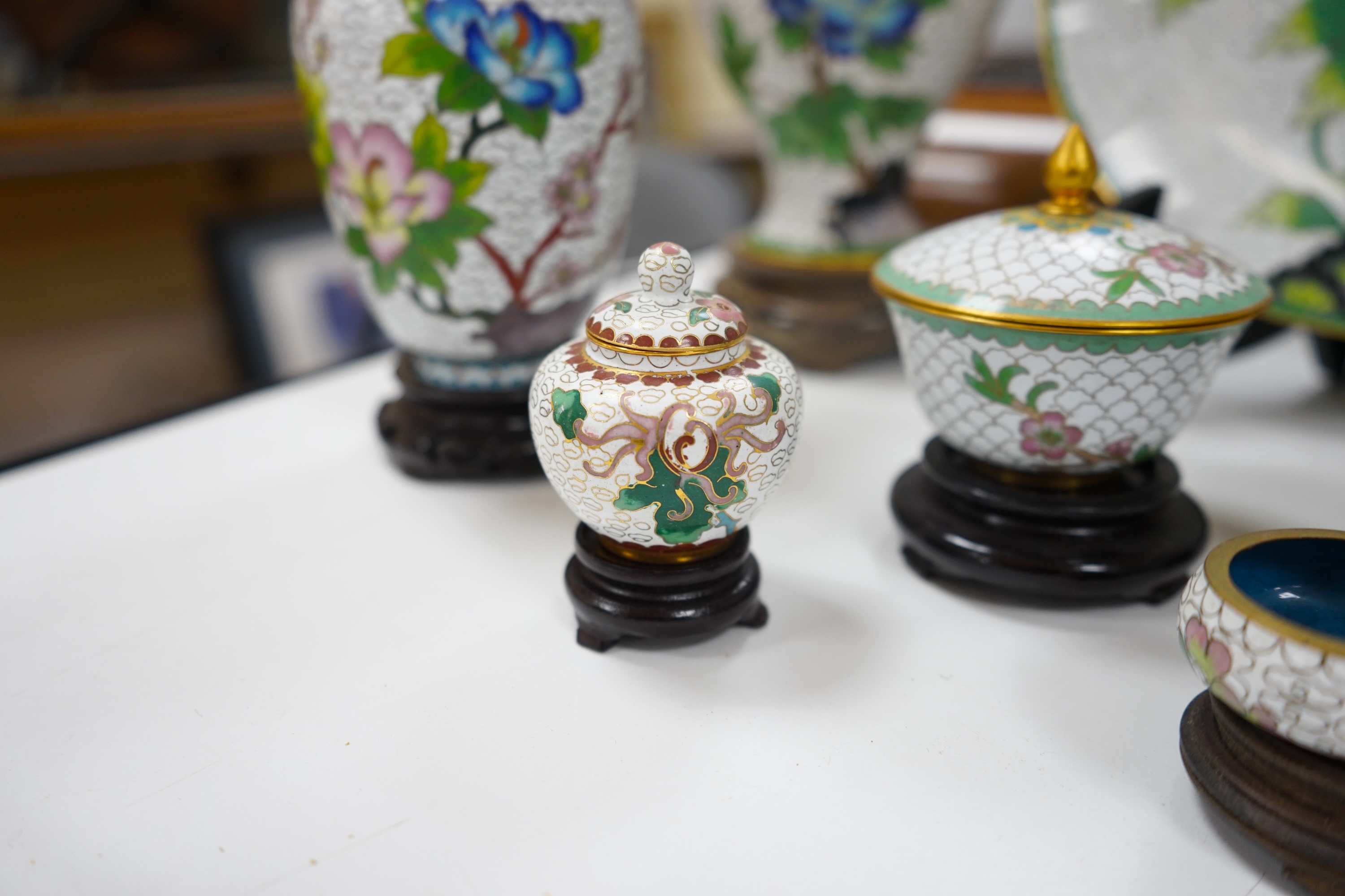 A collection of Chinese cloisonné enamel vases, pots etc., all worked on a white background in floral designs, plate, 20cm diameter. Condition - good